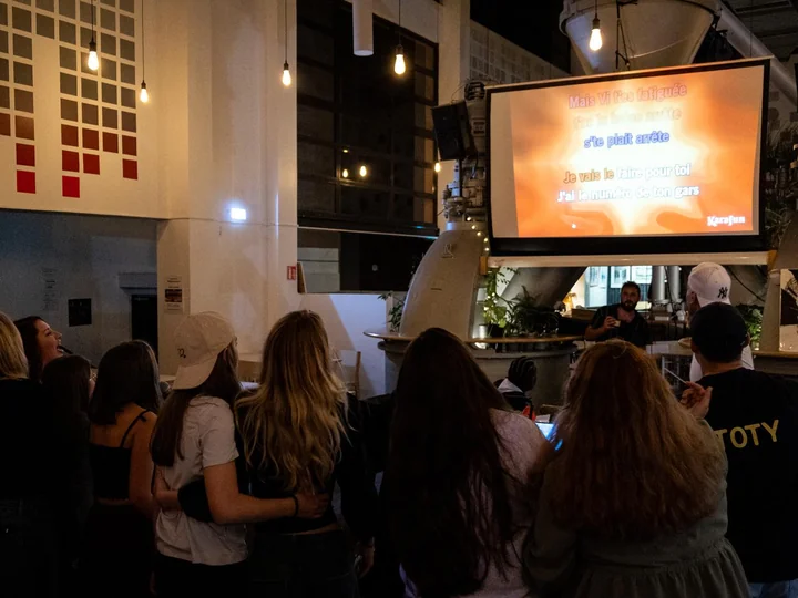 Salle debout devant l'écran pendant un karaoké