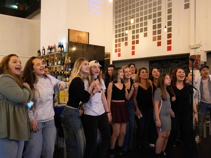 Participants groupés devant le bar pendant une soirée karaoké