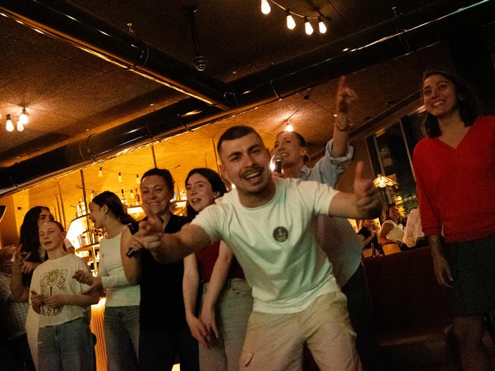Salle de bar pleine pendant un karaoké, bras levés
