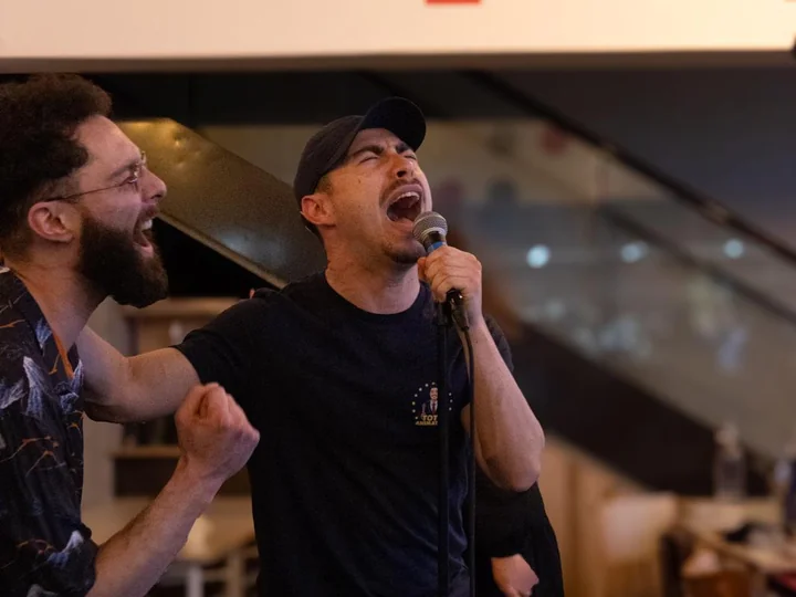 Un participant chante au micro pendant une soirée