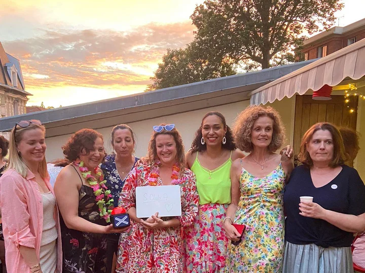 Groupe d'invités en extérieur au coucher du soleil pendant une soirée privée